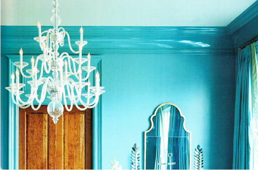 Upper corner of a bright turquoise dining room with chandelier.